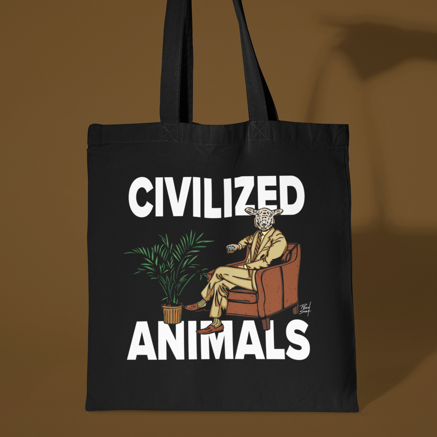 Black tote bag with 'Civilized Animals' graphic design held by a hand against a brown background